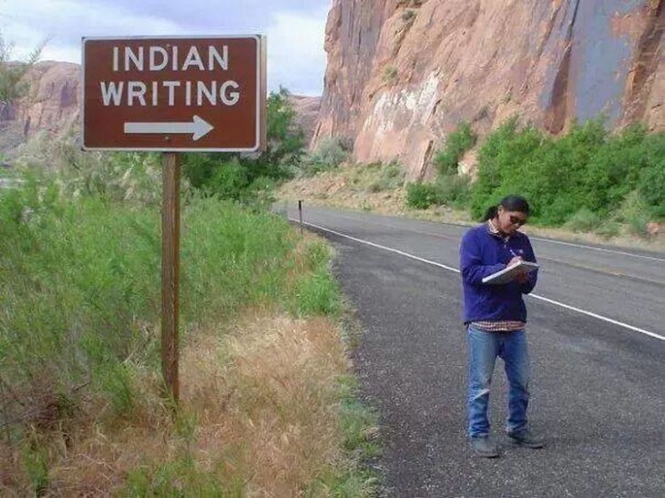 hombre escribiendo a un costado de un letrero que dice 'Indian Writing" 