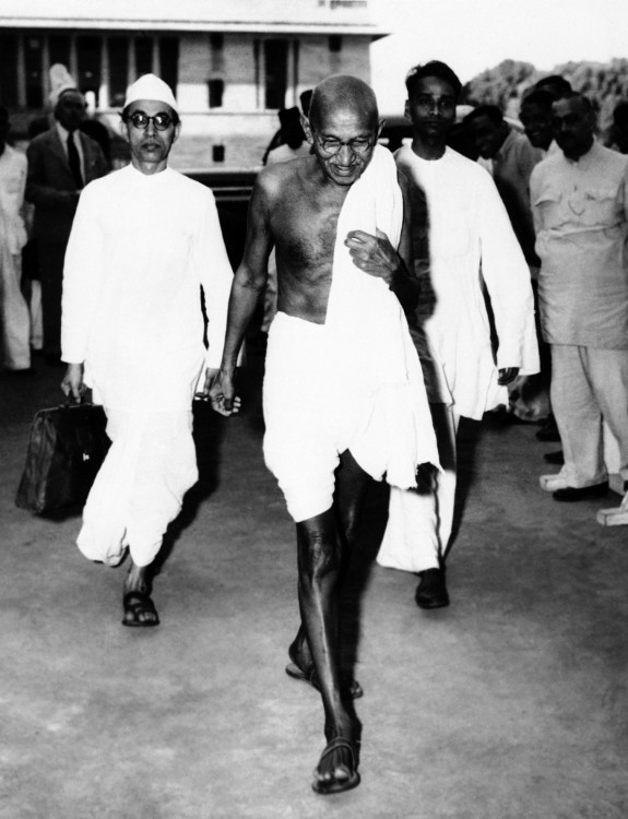 GANDHI CAMINANDO CON DOS HOMBRES DE BLANCO AL FONDO