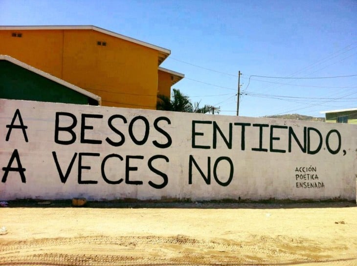 A besos entiendo, a veces no, frase de acción poética en la pared 