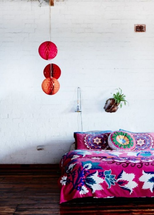 recámara con una cama en colores rosas y muy poca decoración 