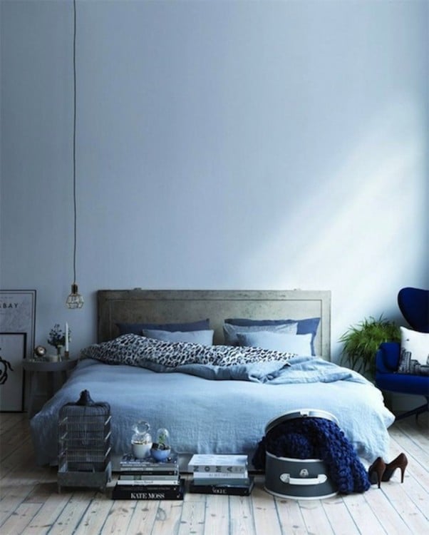 habitación con una cama en color azul y un pequeño foco colgando del techo 