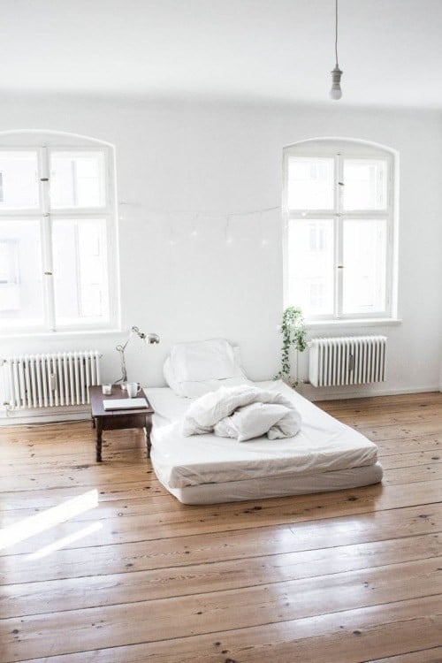 recámara de color blanco con una pequeña cama individual en sábanas blancas 