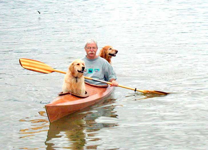 hombre paseando a sus dos perros dentro de un kayak en estados unidos 