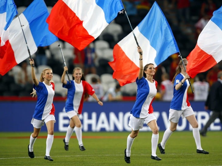 Chicas francesas corriendo por un campo de fútbol 