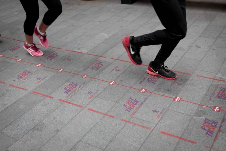 piernas de dos chicas trotando por la vía peatonal rápida del Reino Unido 