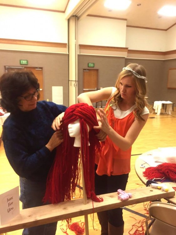 Dos mujeres preparando una peluca de Ariel "La Sirenita" 