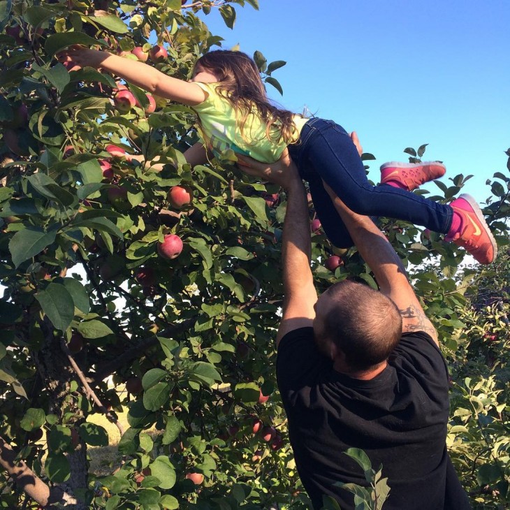 papa ayudando a cortar manzanas a su hija