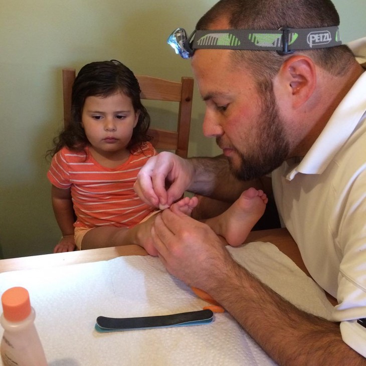 papa cortandole las uñas a su hija