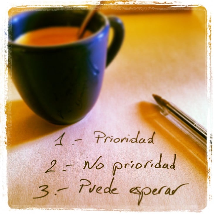 imagen de una taza de café con un papel y una pluma donde escribe prioridades 