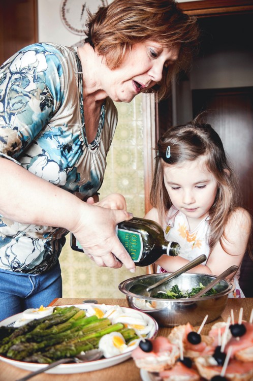 abuela enseñando a cocinar a su nieta 