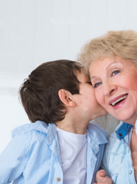 niño platicando al oído con su abuelita 