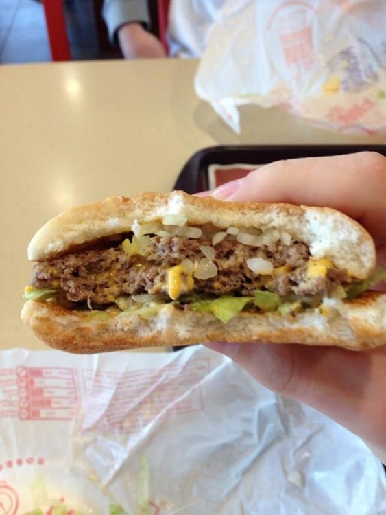 mano de una persona comiendo una hamburguesa de Mc Donald´s 