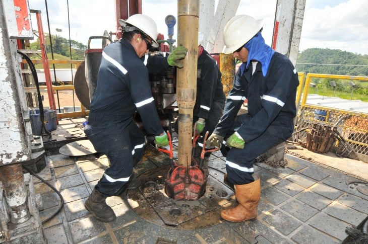 trabajadores de petroleo acomodando una bomba 