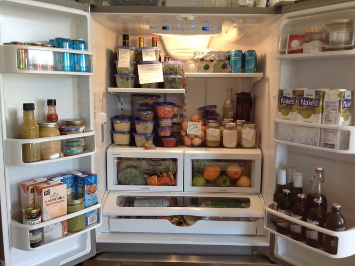 refrigerador abierto mostrando la comida que tiene dentro 