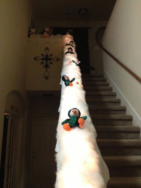 escalera decorada con pingüinos que van resbalándose por la nieve