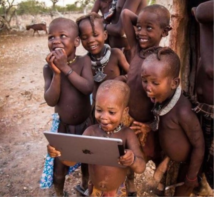 niños africanos felices por ver imagenes en un ipad