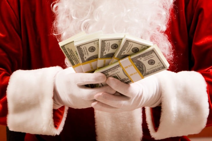 Santa Claus con dinero de presupuesto en la mano