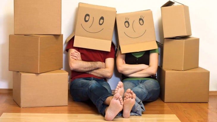 dos personas con cajas de caritas felices en su cabeza sentados sobre el suelo 