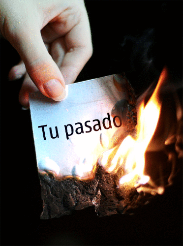 mano de una persona quemando un papel con la frase "Tu pasado" 