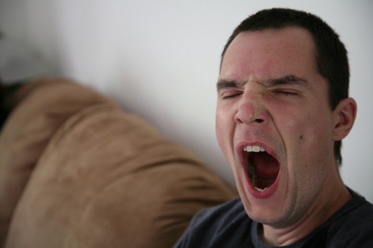 cara de un chico bostezando sentado en un sillón 