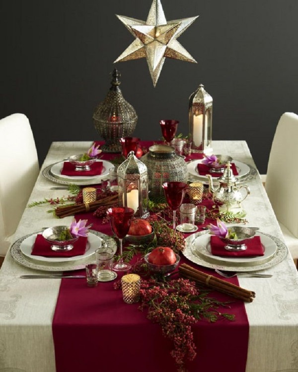 decoración de una mesa de navidad con copas, veladoras y frascos 