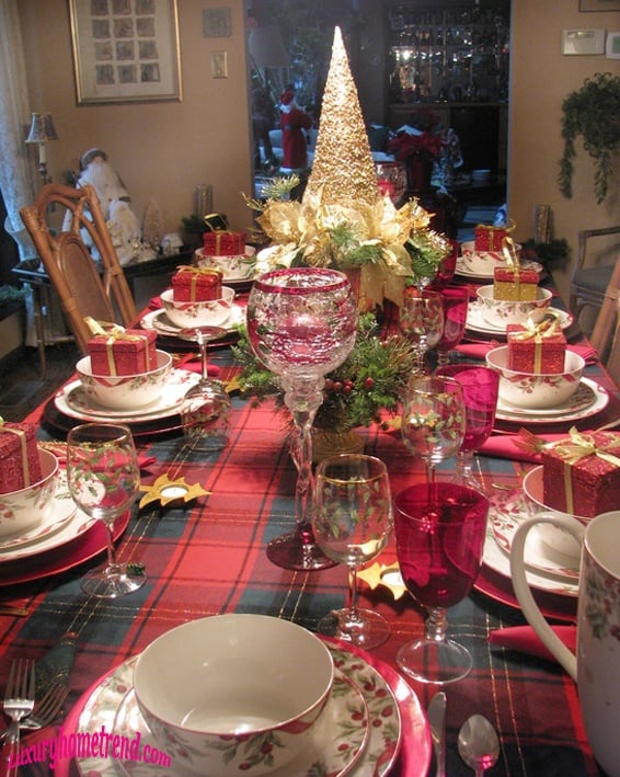 mesa de navidad adornada con un pequeño árbol de navidad y flores de colores 