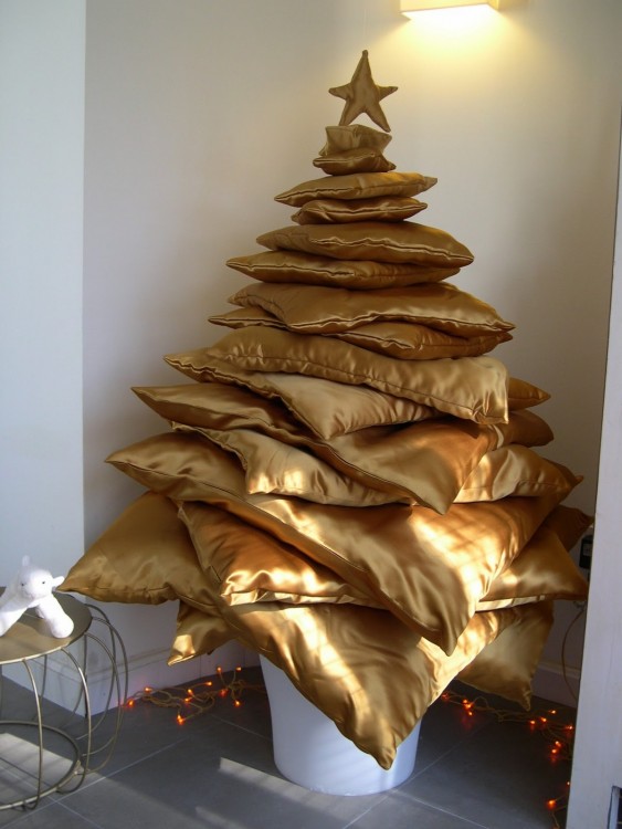 Rincón de la casa adornado con un árbol de navidad hecho con almohadas 