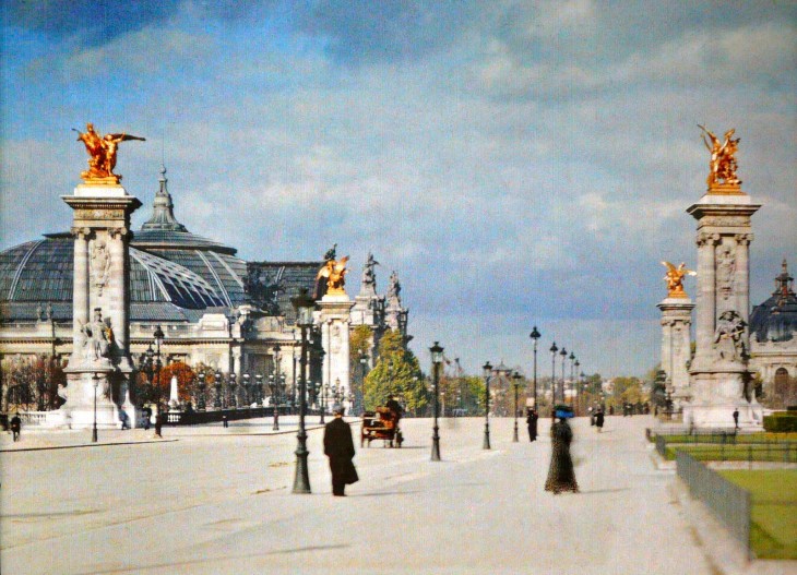 Personas caminando a mitad de la calle por París en el siglo XX 