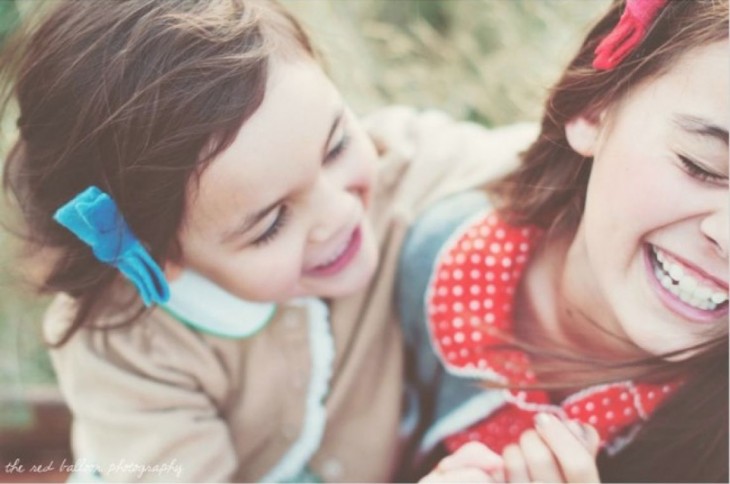 foto de dos niñas sonriendo la una con la otra 