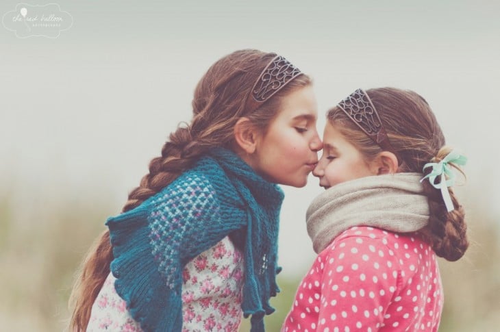 foto de una niña dando un beso en la nariz de su hermana 