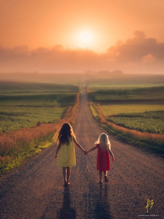 Dos niñas caminando por un camino agarradas de la mano 