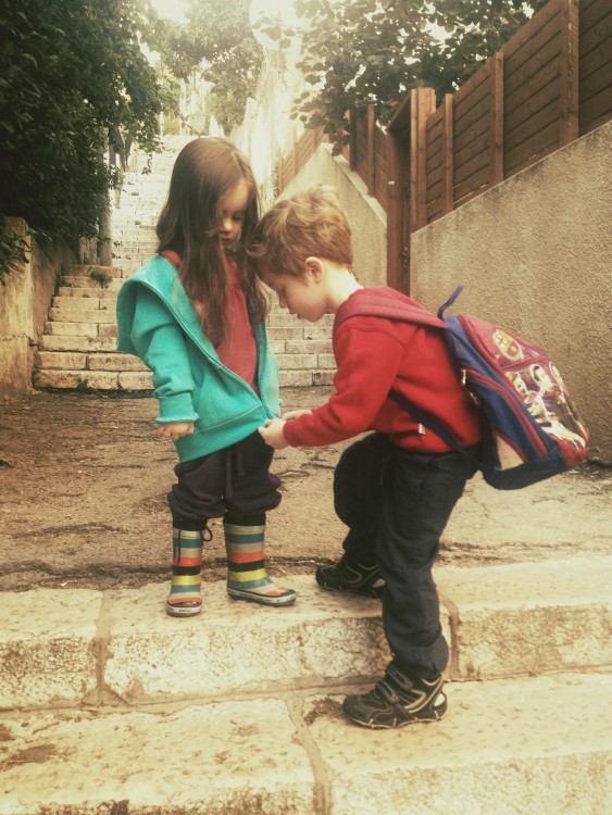 niño abrochando la chamarra de su hermanita 