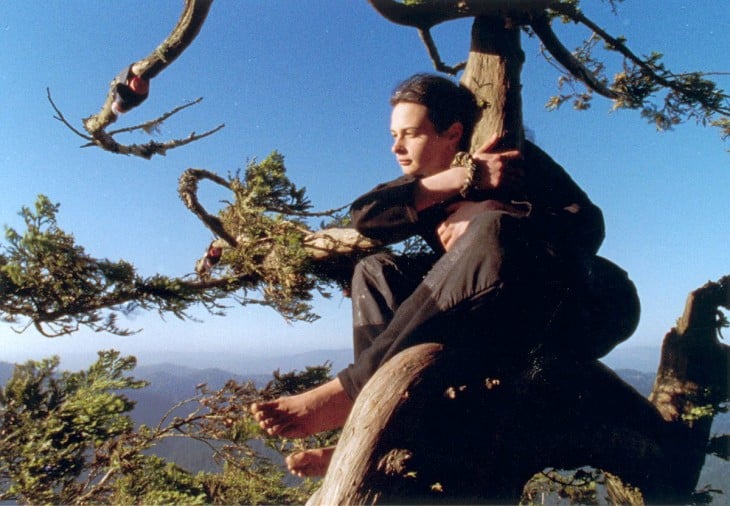 JULIA ABRAZADA DE LA RAMA DE UN ARBOL LLAMDO LUNA