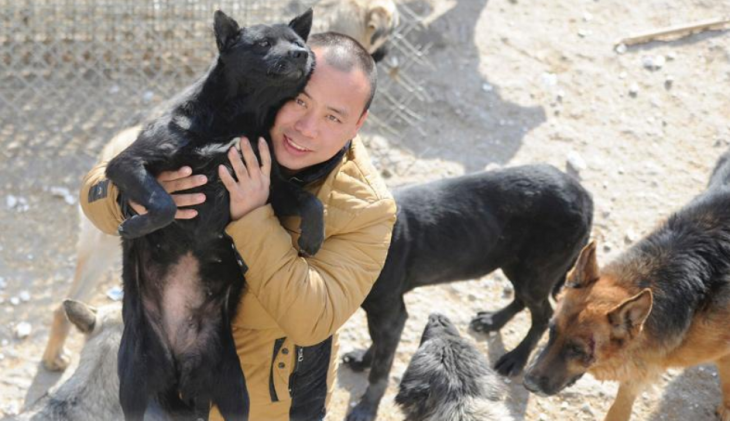 Wang Yan cargando un perro en su refugio en china 
