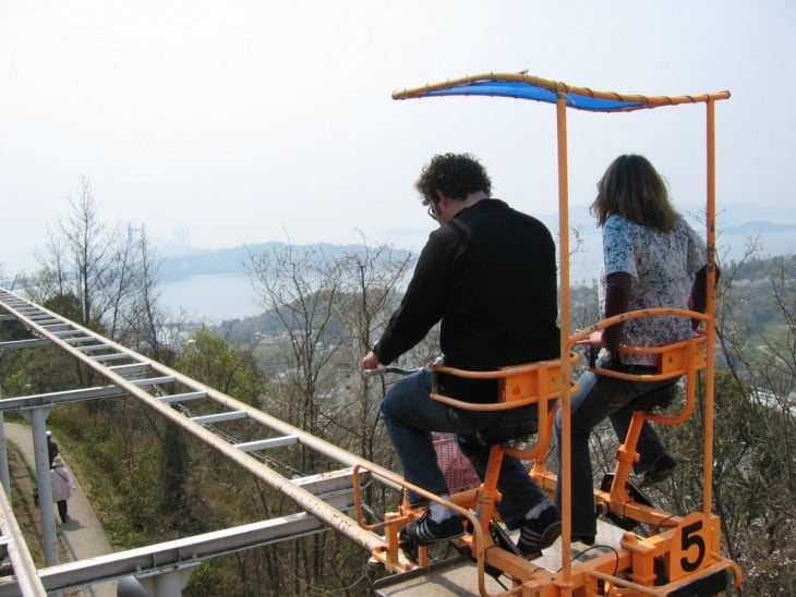 pareja de personas en un carrito de la montaña rusa en Japón 