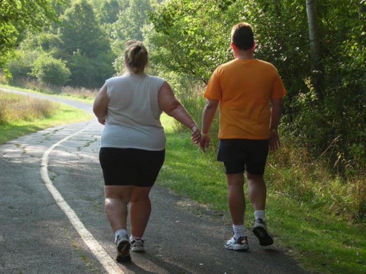 Personas obesas intentando hacer ejercicio al aire libre