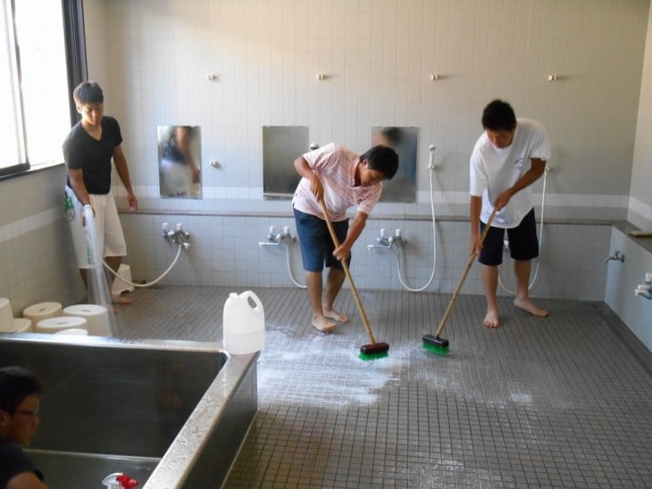 chicos en Japón limpiando los baños de su escuela 