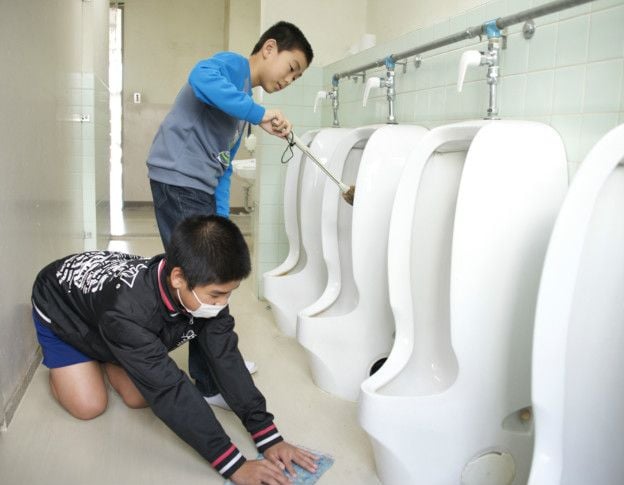 niños japoneses limpiando los baños de sus escuelas 