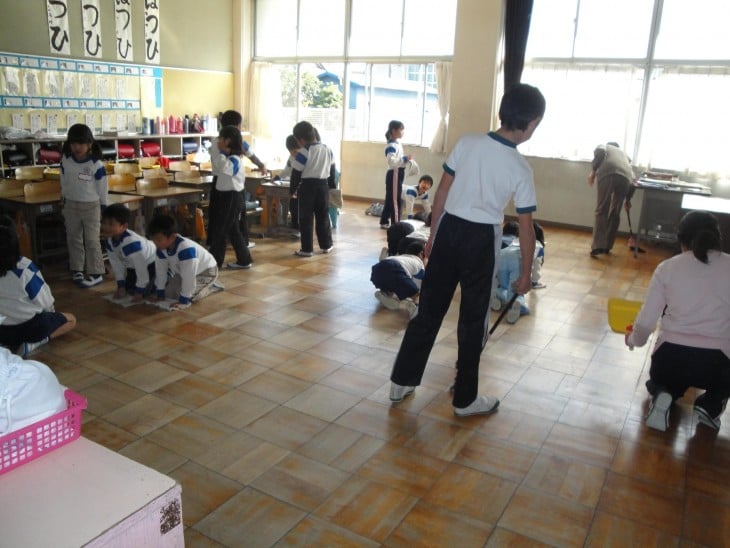 Niños japoneses haciendo la limpieza en su salón de clases 