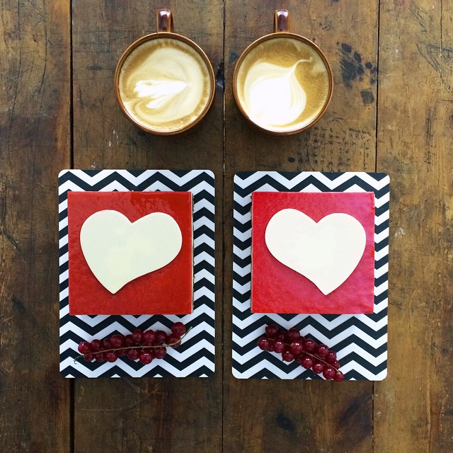 platillo con dos figuras de corazón simétricas a dos tazas de café 