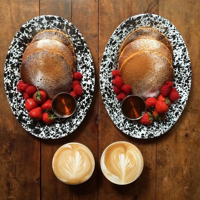 Platillo de hot cakes con fresas simétrico a dos tazas de café 