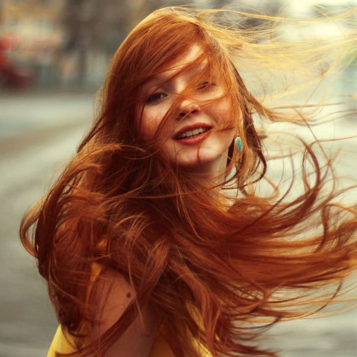 fotografía de una chica pelirroja jugando con su cabello 