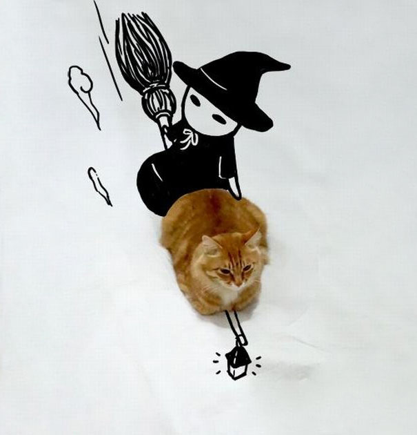 Gato con un dibujo de una bruja sentada sobre él 