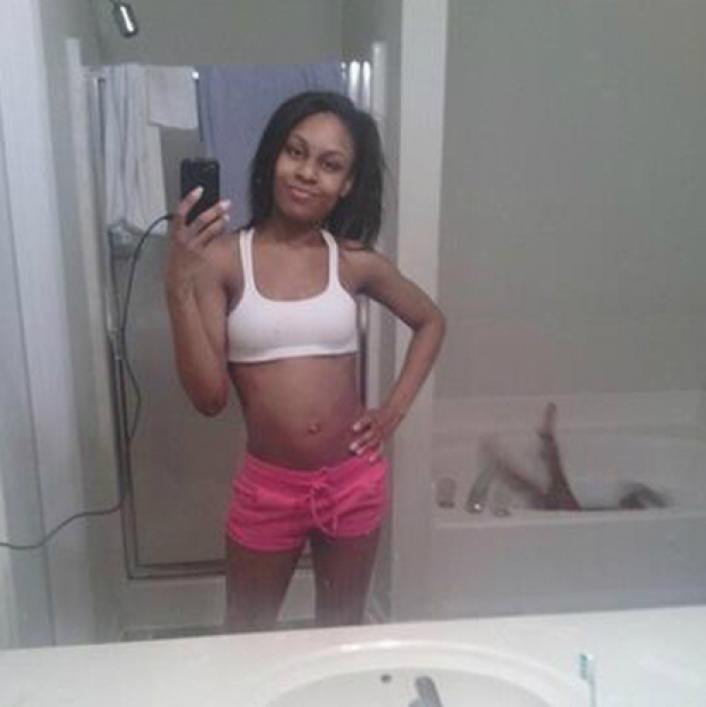 mujer tomándose una foto en el espejo mientras su hijo se cae en la bañera 