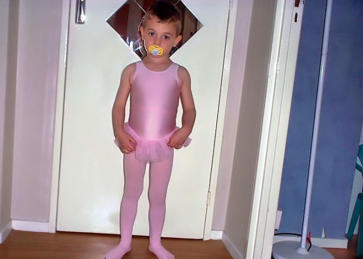 fotografía de un niño vestido con un traje en color rosa 
