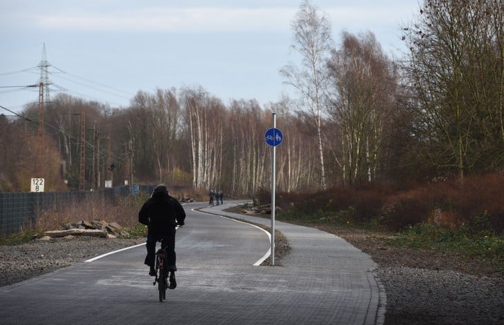 hombre en bicicleta transitando sobre la carretera para bicicletas en Alemania 