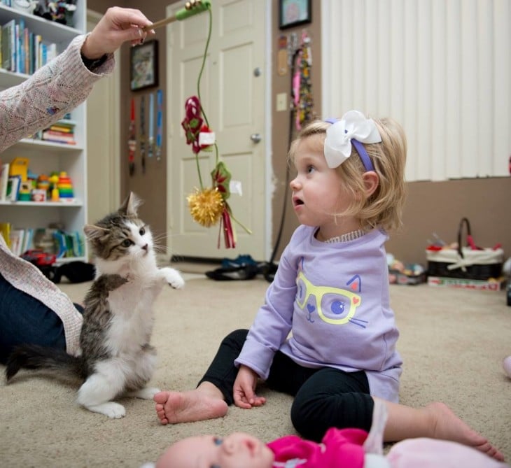 Scarlette niña sin un brazo jugando con su mamá y su gato de 3 patas 