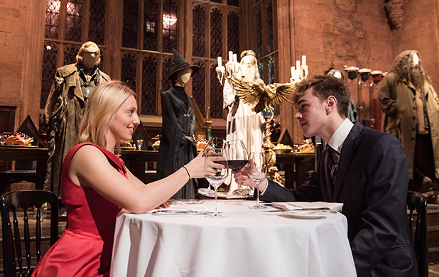 Personas brindando con dos copas en el Gran Salón de Hogwarts en Londres 