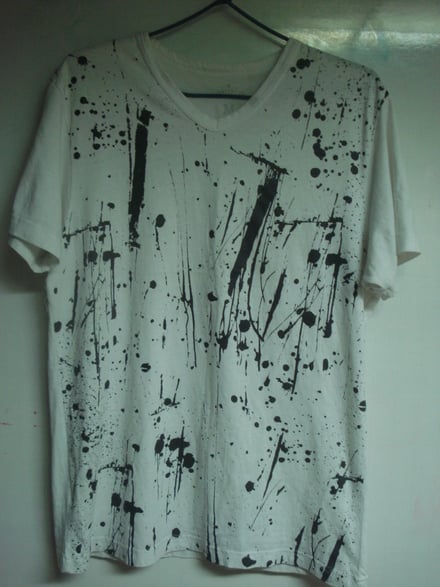 camisa blanca llena de manchas de pintura negra 