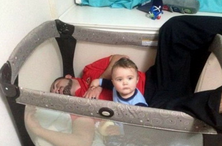 hombre dormido dentro de la cuna de su bebé 